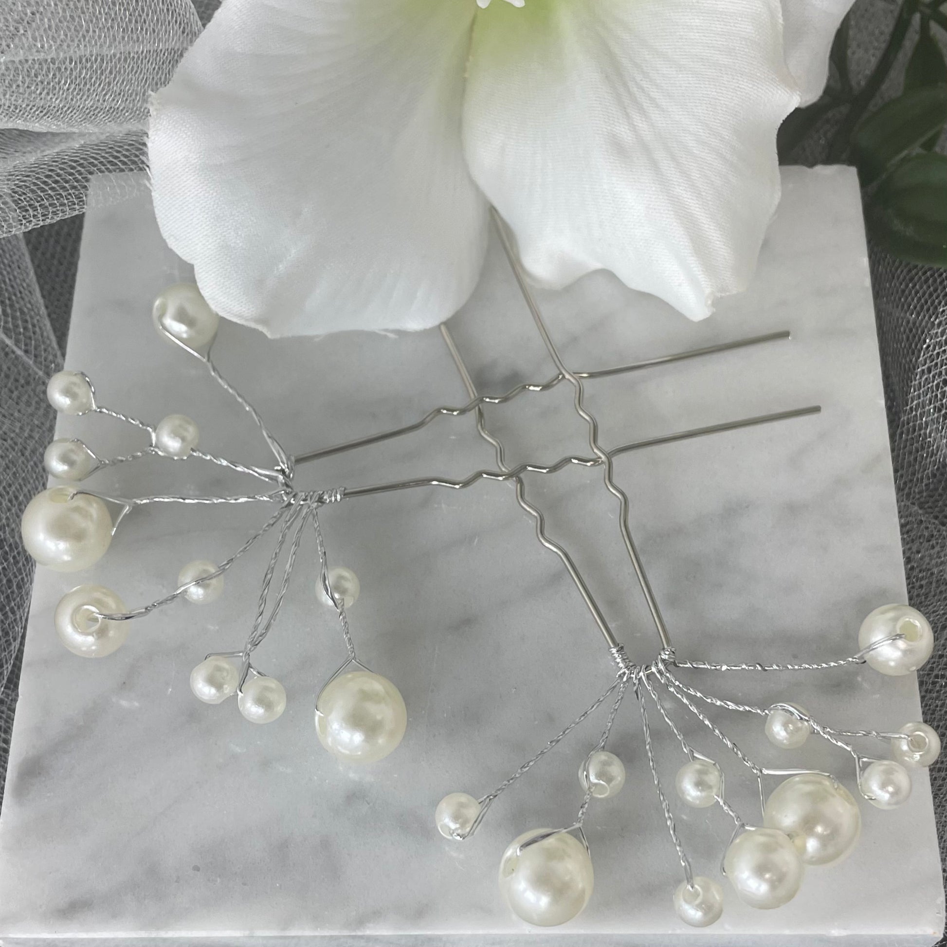 Delicate bridal hairpin adorned with four large and seven small pearls, perfect for adding a touch of classic elegance to any bridal or formal hairstyle.