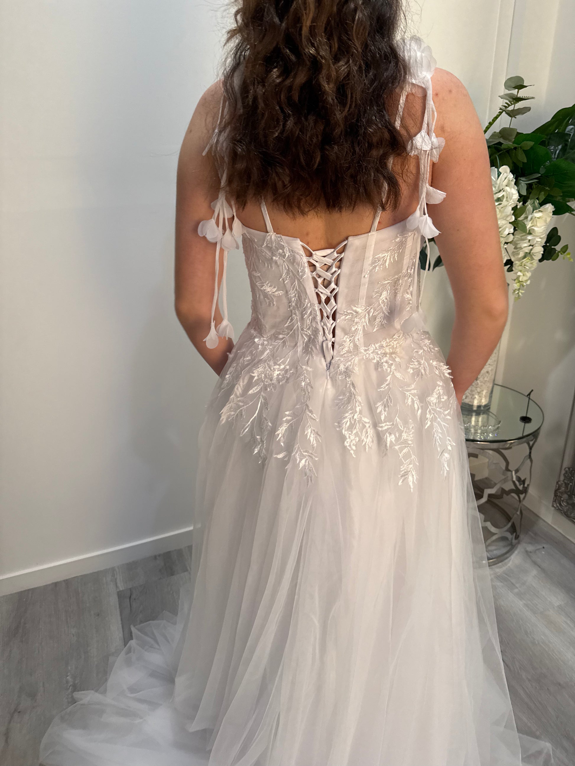 White lace debutante dress with a plain background