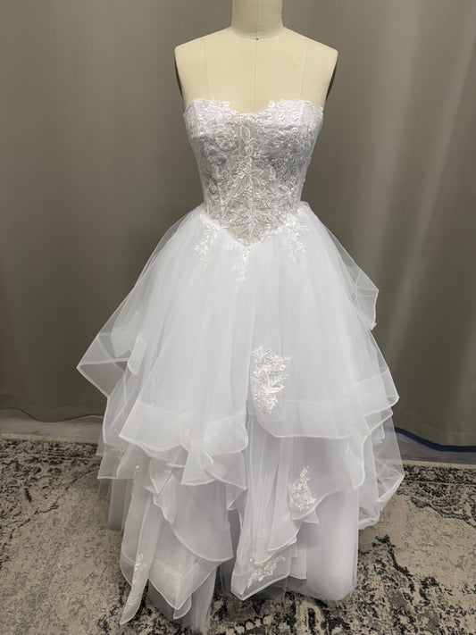 Kasey V1 white lace appliqué debutante dress, front view on mannequin with floral lace corset and full ruffle skirt