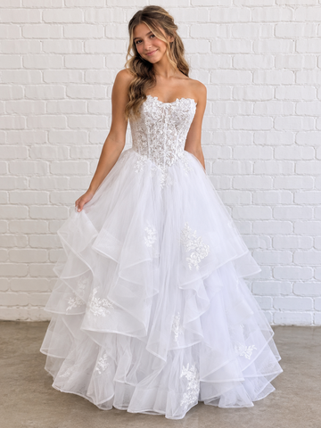 Kasey V1 white lace appliqué debutante dress, front view on model with floral lace corset and full ruffle skirt