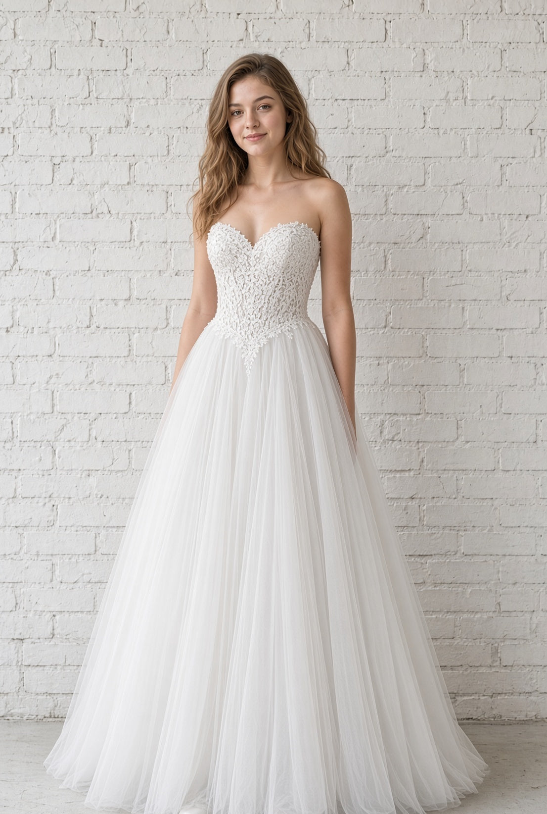 Leona V1 white embroidered corset debutante dress, front view on model with strapless lace bodice and full tulle skirt
