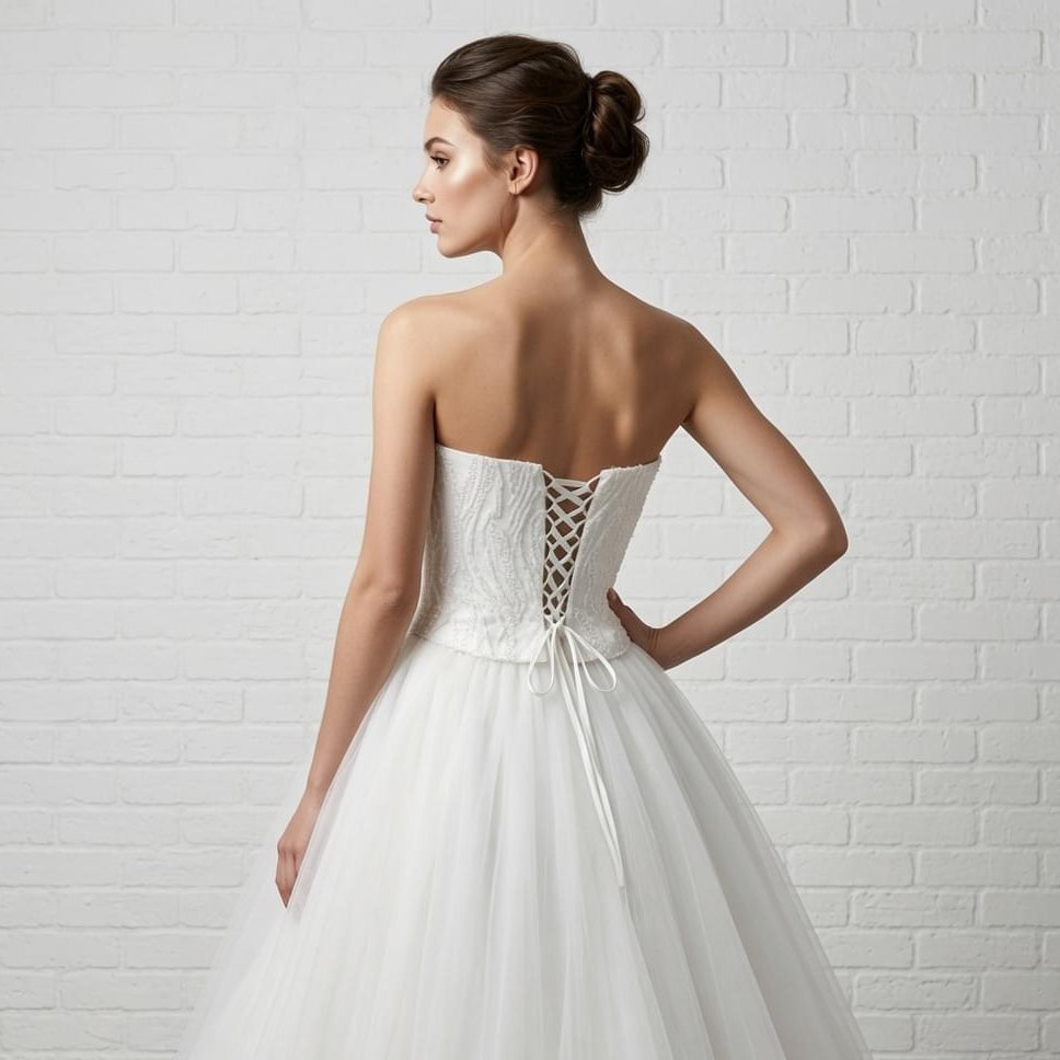 Back view of elegant white strapless debutante dress with detailed lace-up corset back and sequined bodice.