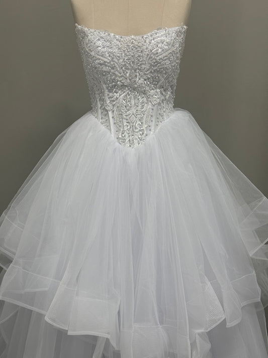 Loretta V1 white pearl debutante dress, front view on mannequin with lace corset and full ruffle skirt