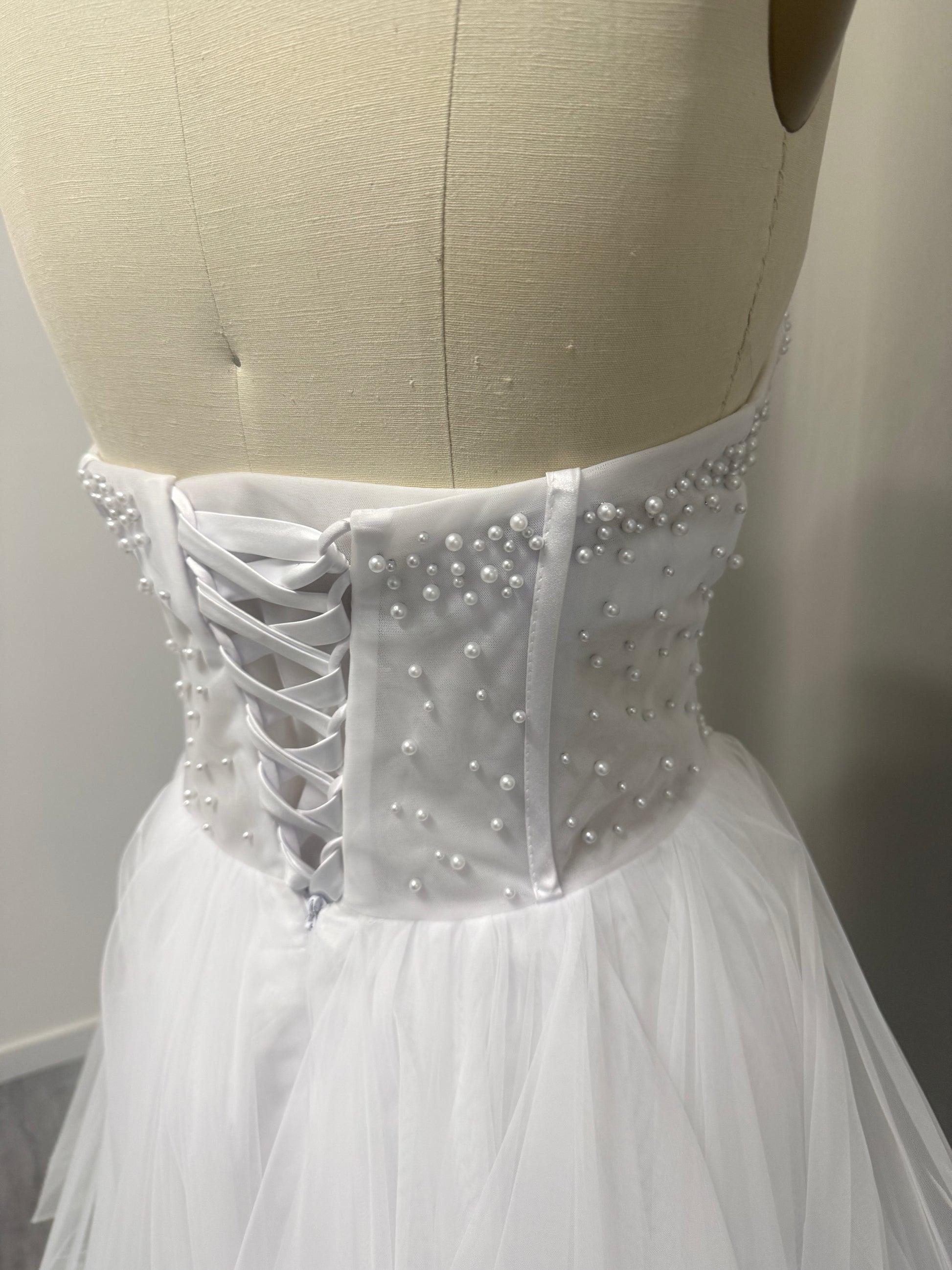 Close-up of Lyra Debutante Ball Gown corset back with pearl beading and lace-up detailing