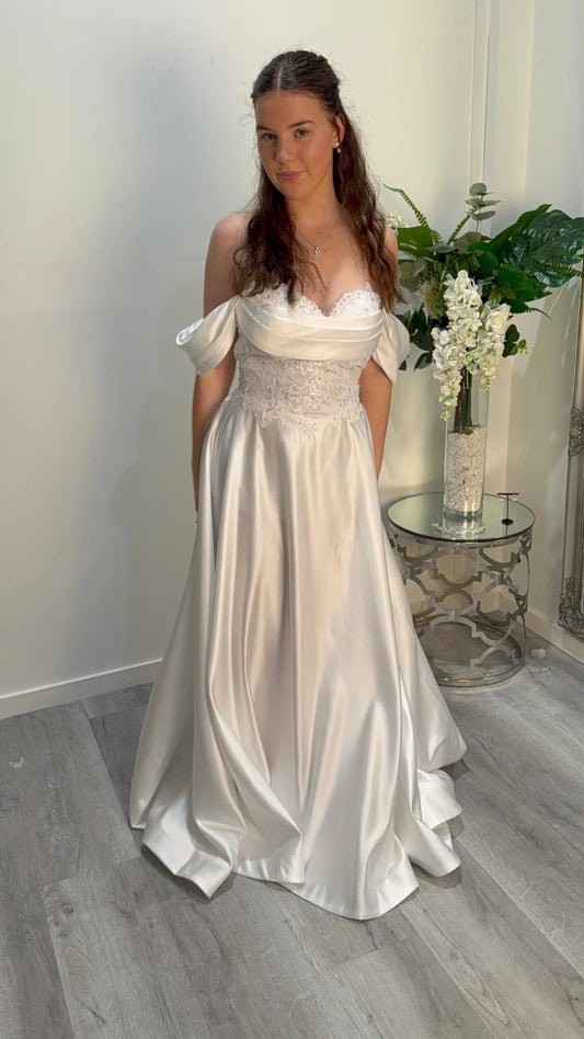 Woman in a white deb dress standing indoors with decor in the background