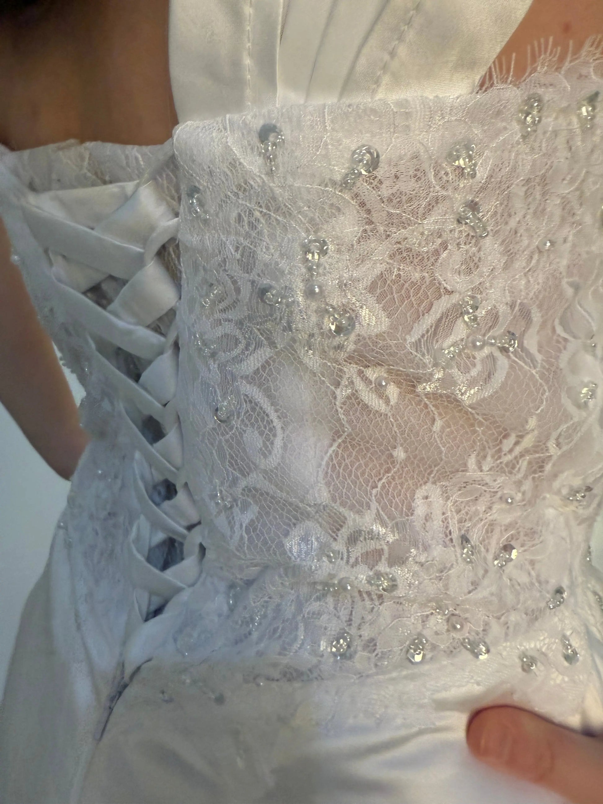 Close-up of a white lace glove with decorative beads
