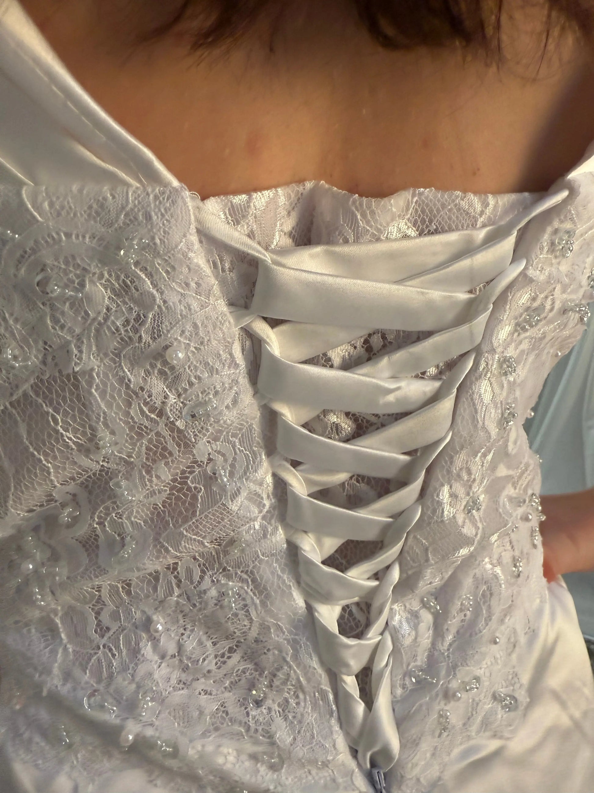 Close-up of Mica Debutante Dress – White lace deb dress.
