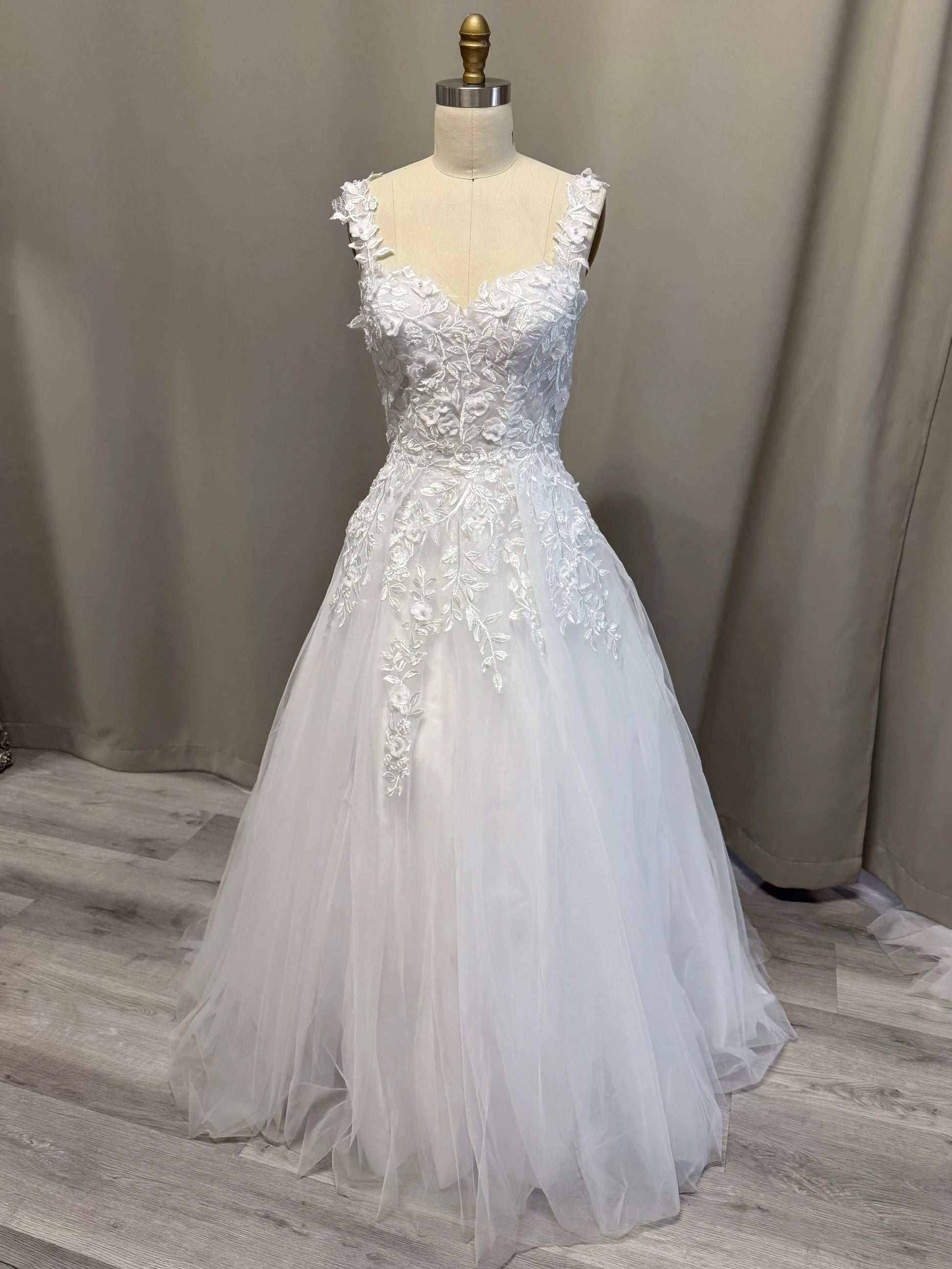 White debutante dress on a mannequin against a neutral background