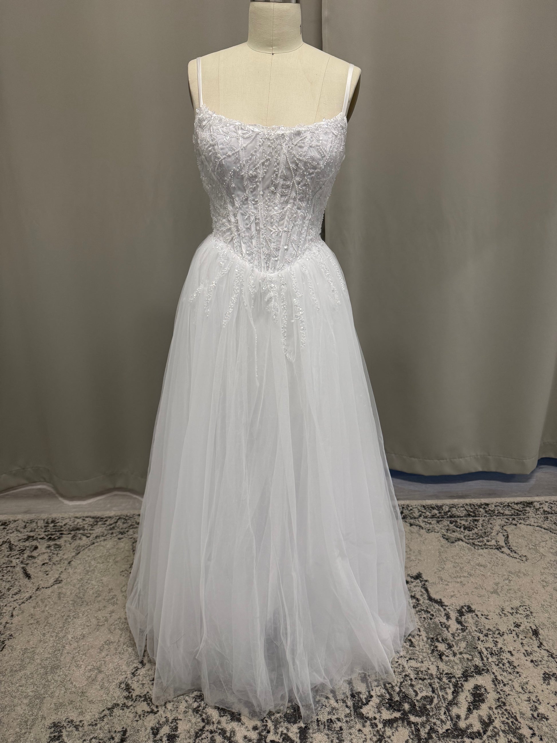 Molly V1 white spaghetti strap debutante dress, front view on mannequin with beaded corset and full tulle skirt