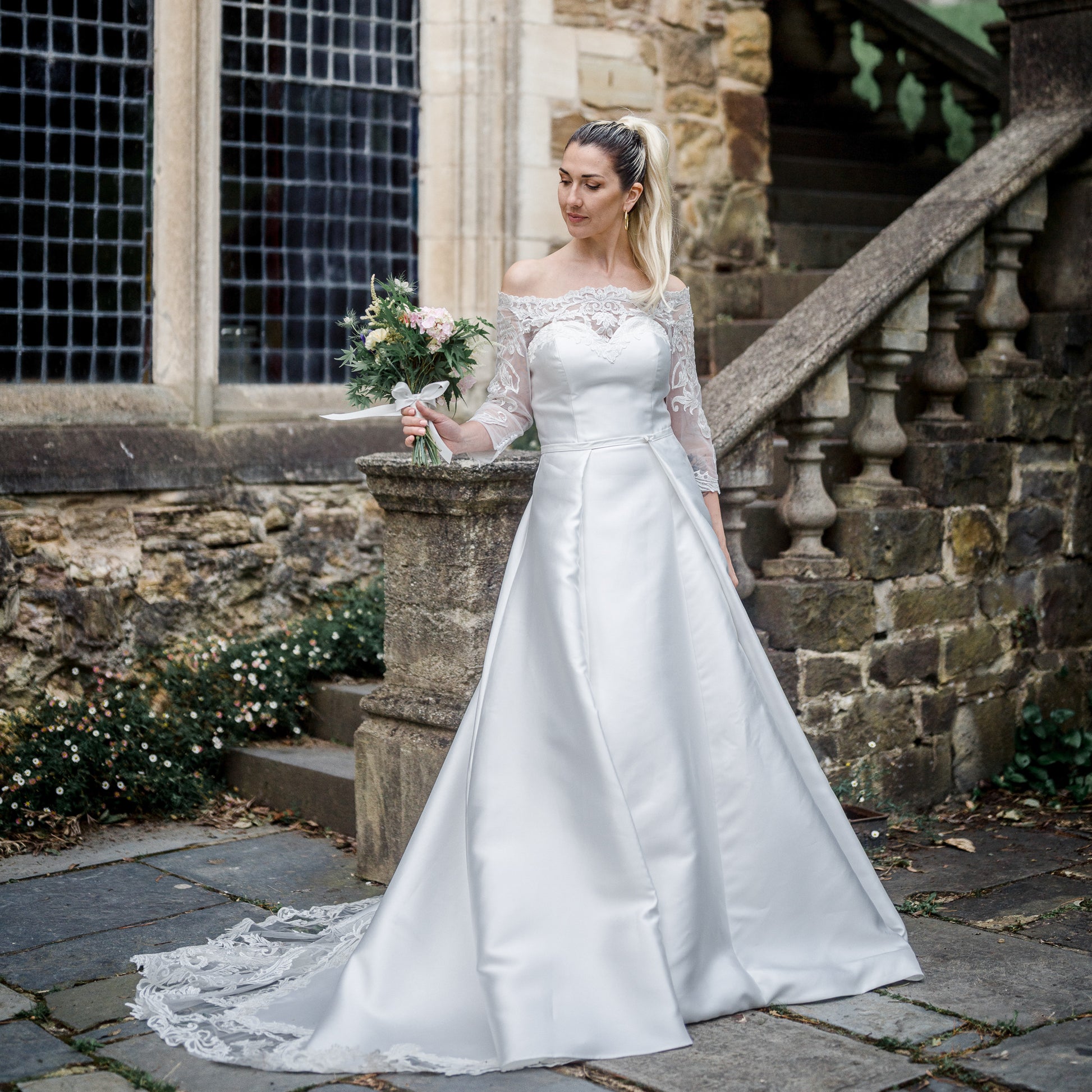 Summer wedding dress with a lace-adorned sweetheart neckline, detachable sleeves, and a flowing train.