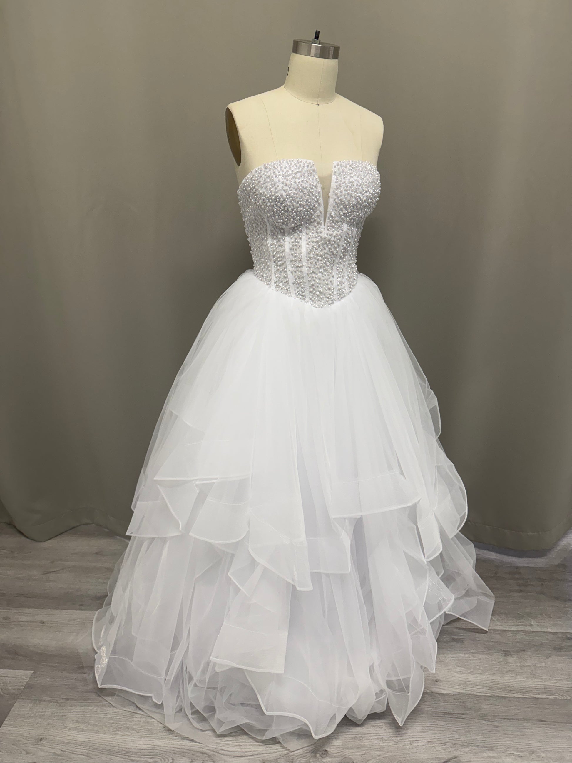 Ophelia Ruffled Pearl Beaded Strapless Debutante Ball Gown on mannequin - white pearl beaded corset with multi-layered ruffled tulle skirt
