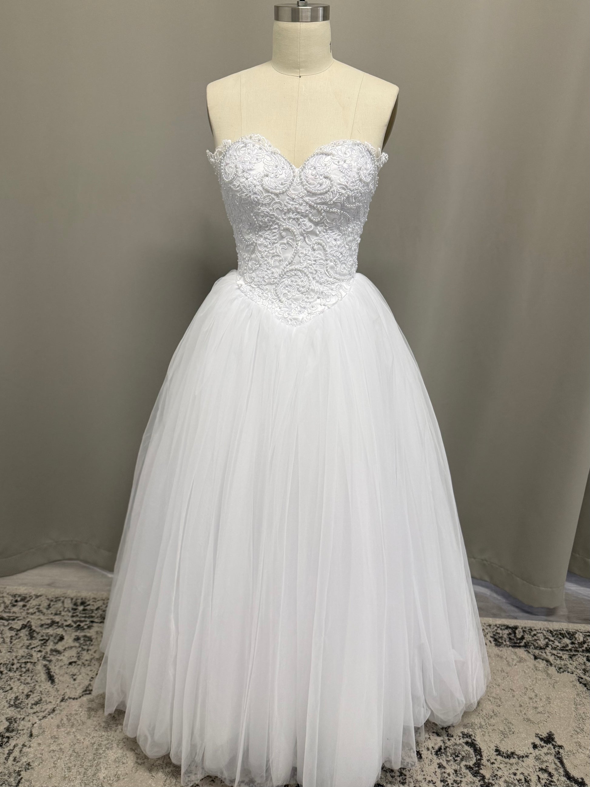 Periana V1 white formal debutante dress, front view on mannequin with pearl lace corset and full tulle skirt