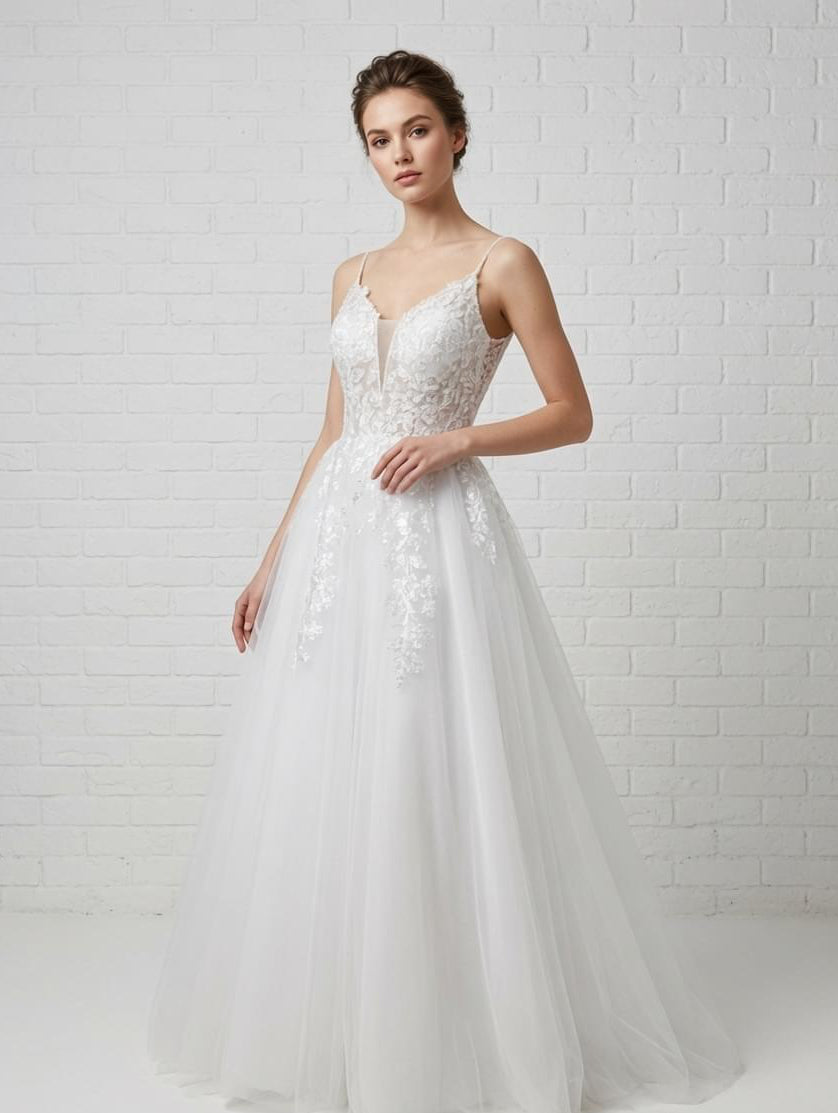 White debutante gown with a lace bodice, illusion plunge neckline and soft flowing tulle skirt.
