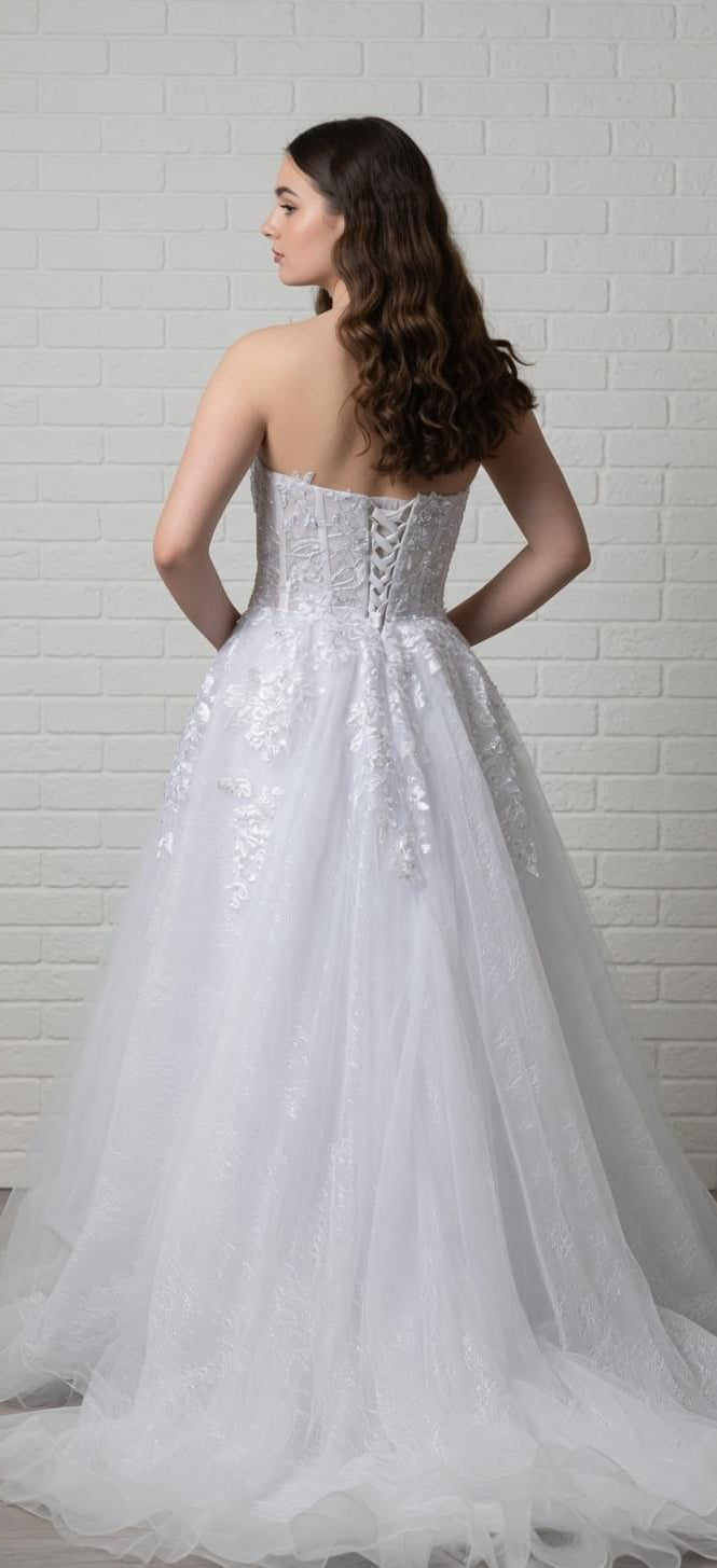 White debutante dress with a lace-up corset bodice, lace appliqué detailing, and a full  tulle skirt.