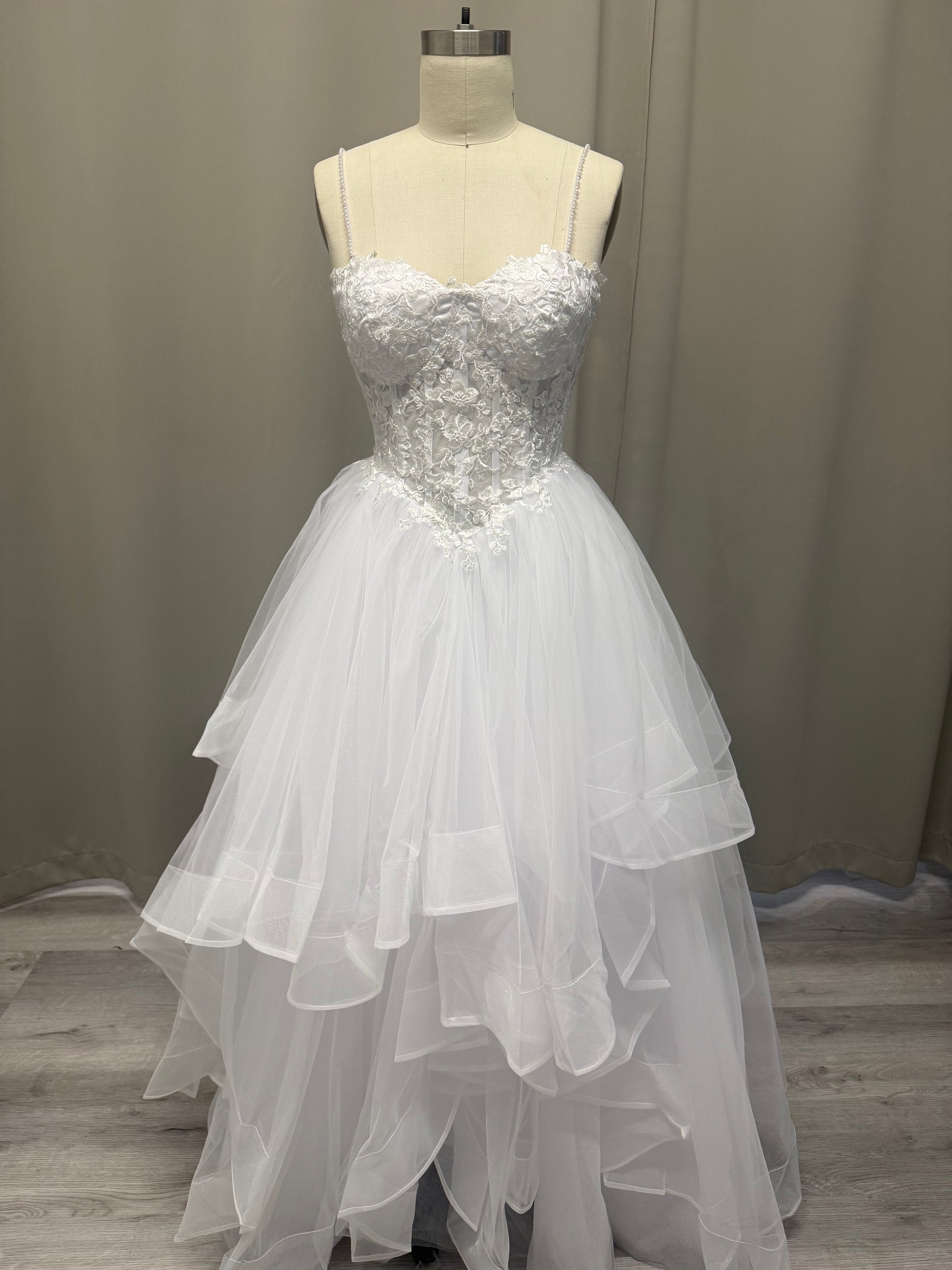 Riva white lace debutante dress, front view on mannequin with pearl straps, sweetheart bodice and layered tulle skirt