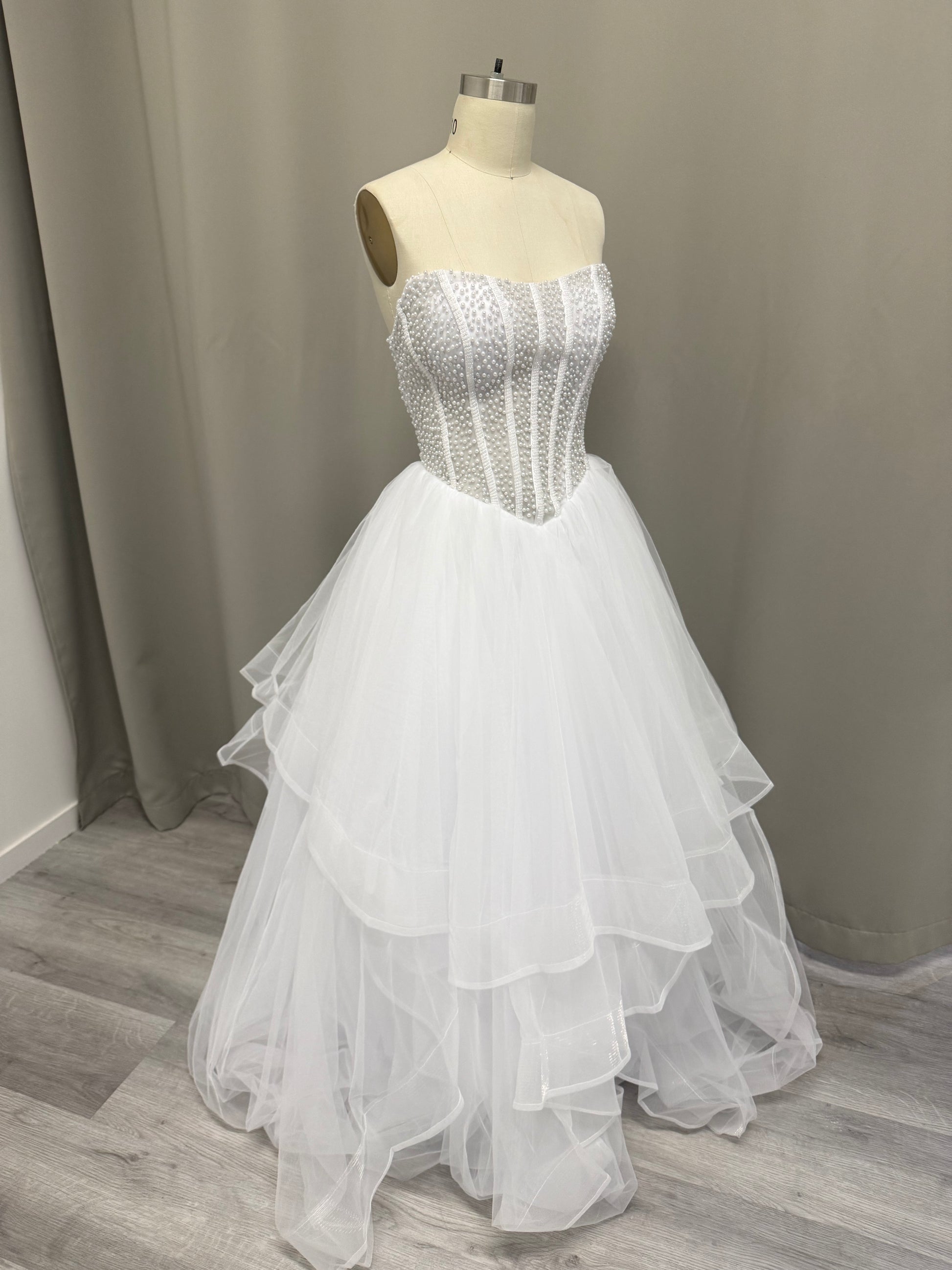 Siren Pearl Beaded Strapless Debutante Ball Gown on mannequin - white pearl corset bodice with layered high-low tulle skirt