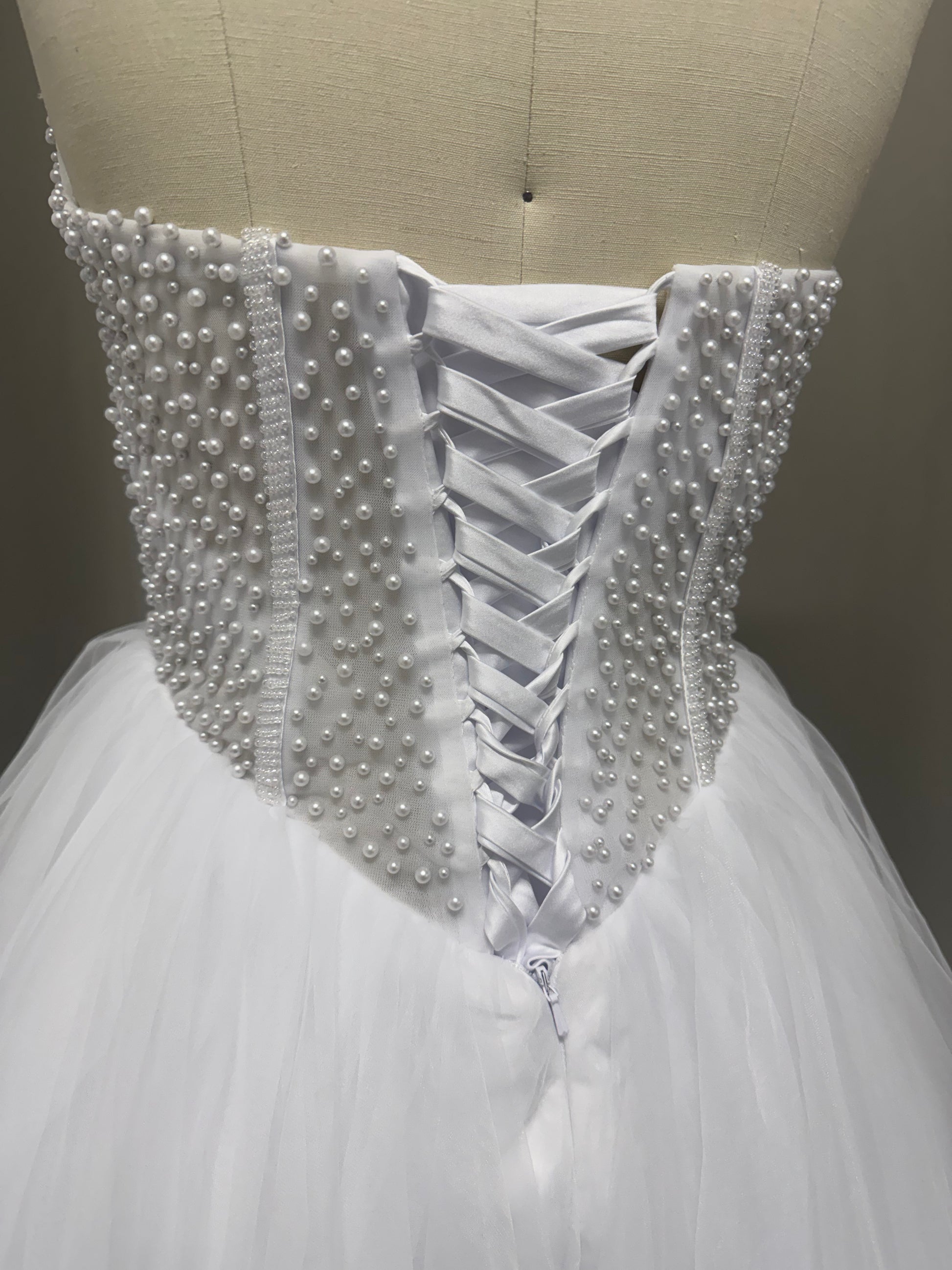 Close-up of Siren Debutante Ball Gown corset back showing pearl beading and lace-up ribbon detailing