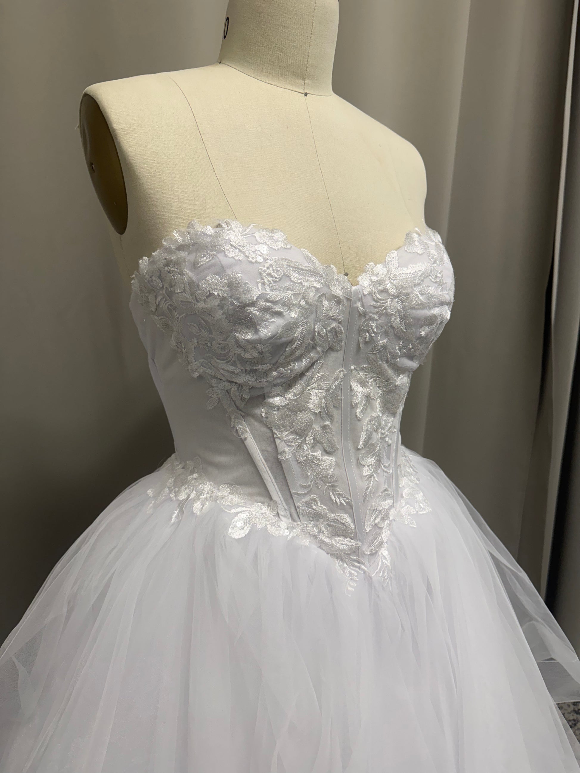 Close-up of Skye V1 floral lace debutante dress strapless sweetheart bodice with floral lace appliqué