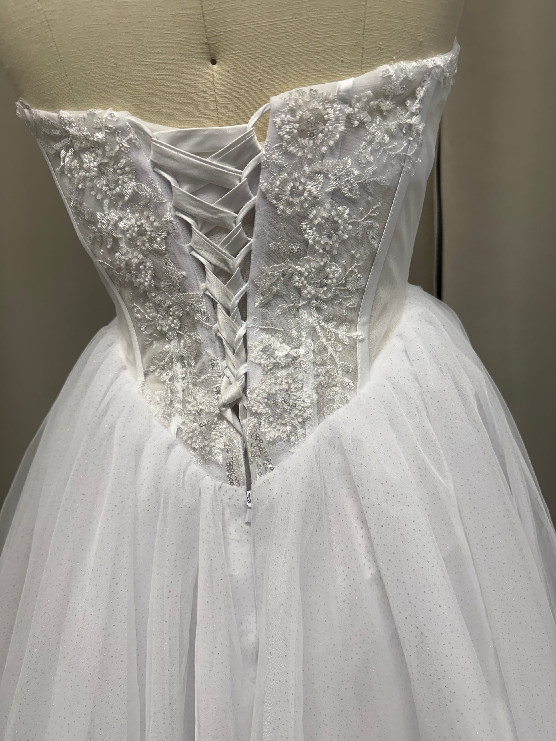 Trish V1 debutante gown back view showing lace-up corset, floral lace appliqué and sparkle tulle skirt
