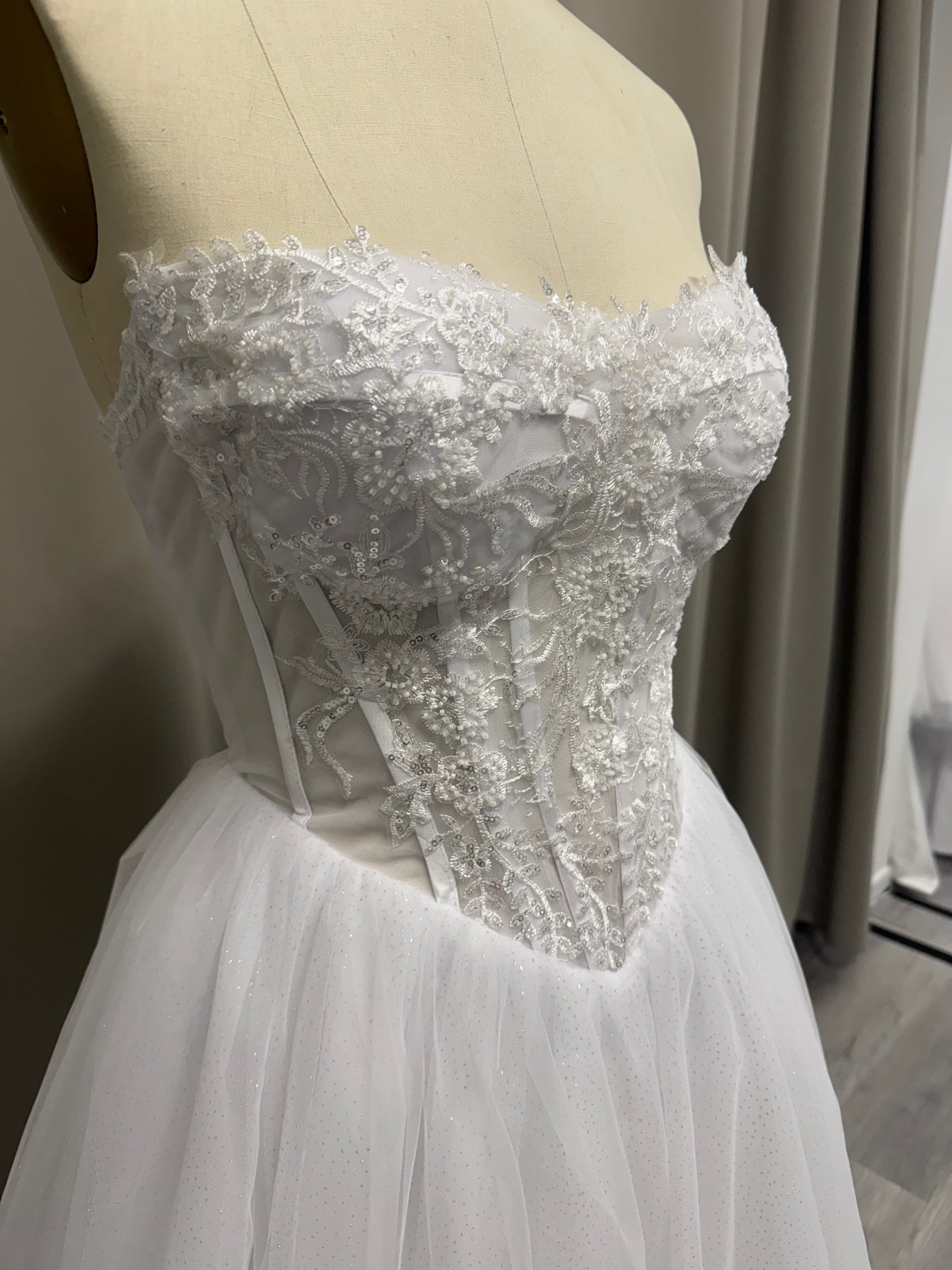 Close-up of Trish V1 debutante gown strapless sweetheart lace bodice with sequin floral appliqué