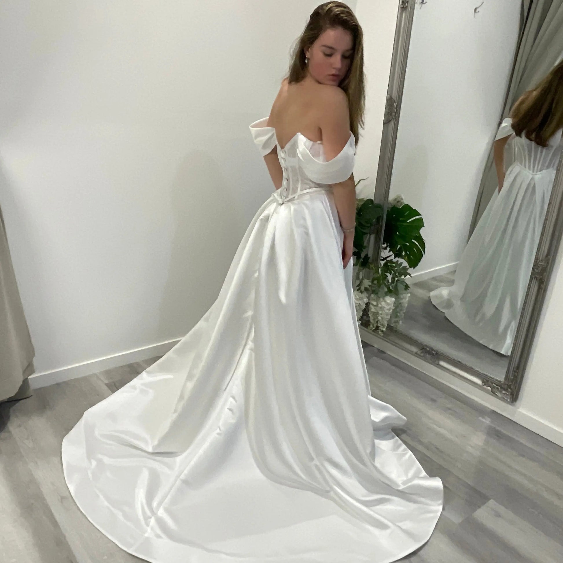 Side back view of Vallorie Debutante Dress highlighting the lace corset bodice and pleated satin A-line skirt, creating a soft, flowing silhouette.