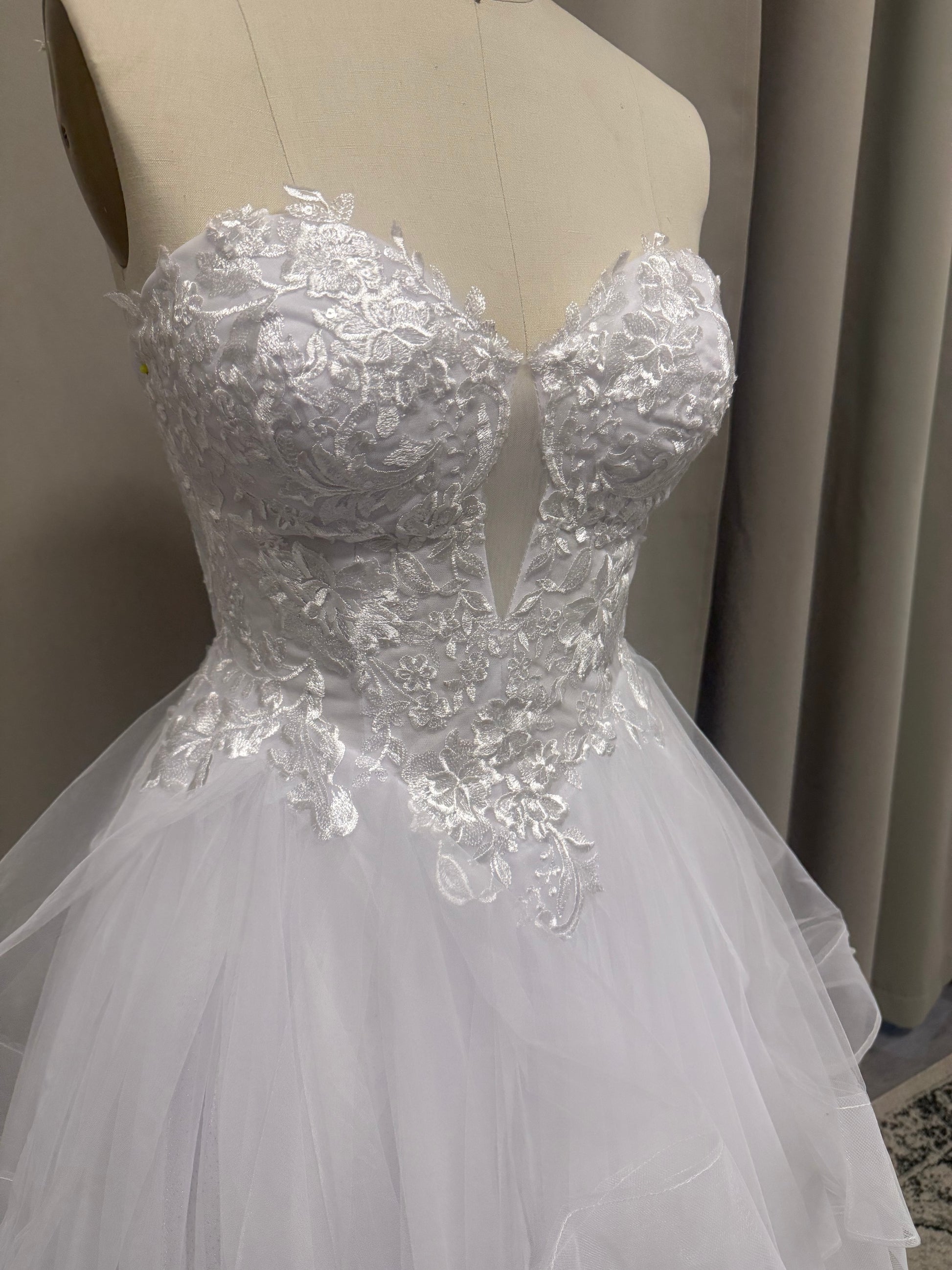 Close-up of Willow V1 plunge neck debutante dress strapless sweetheart bodice with centre plunge and floral lace appliqué