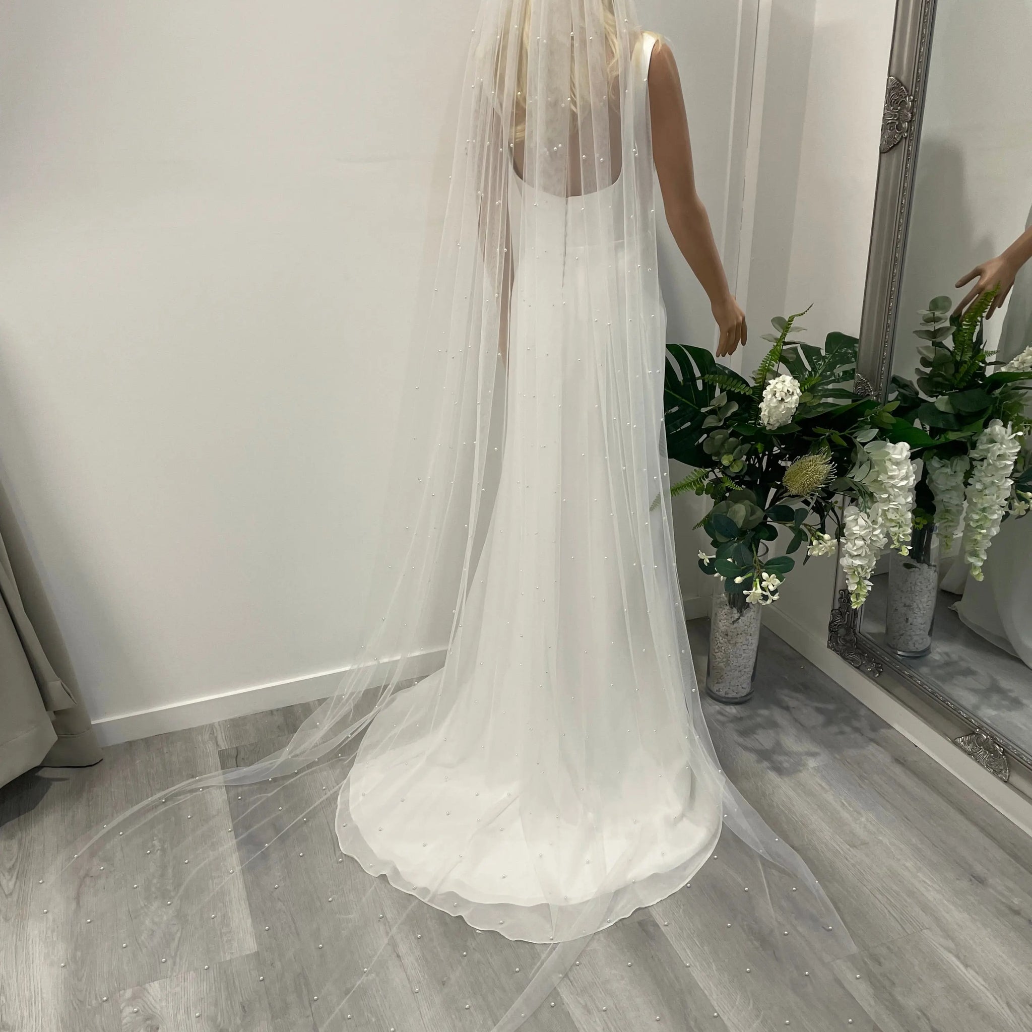 Back view of bride wearing 2.5m pearl bridal veil with long cathedral train and metal comb