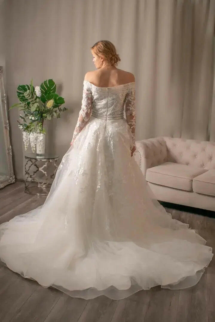 Back view of Diana off the shoulder lace wedding dress with draped lace bodice and flowing ball gown skirt