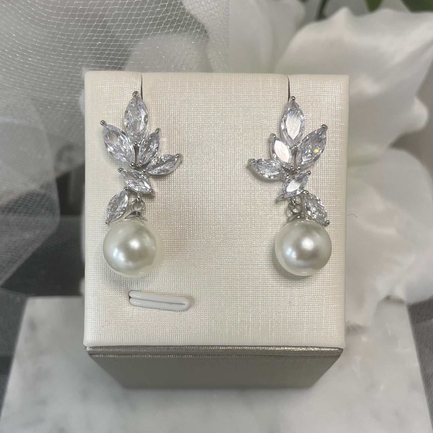 Celeste earrings with cascading leaf-like crystals and a central pearl in rose gold & silver.