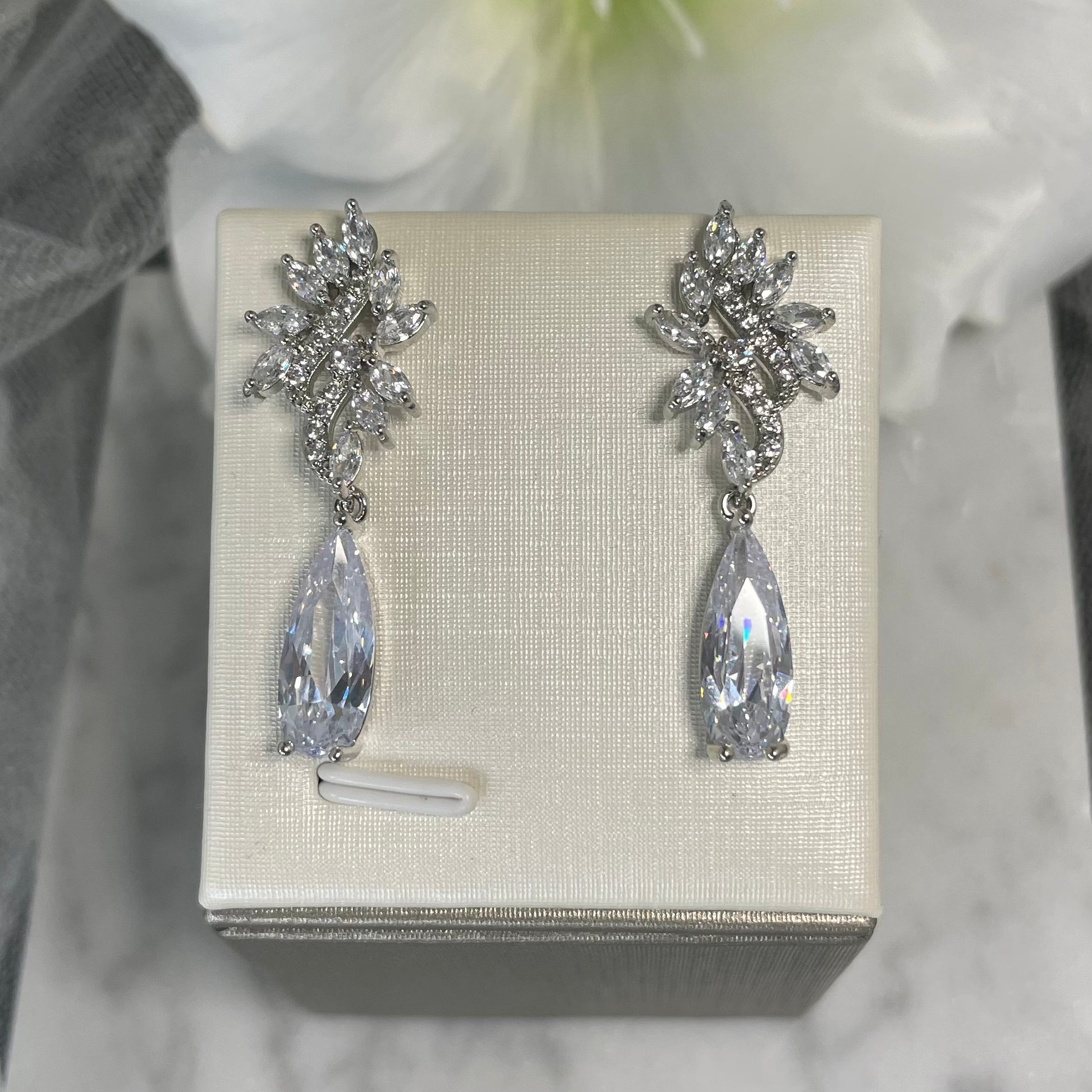 Kirsty crystal earrings featuring a wavy leaf design and clusters of sparkling cubic zirconia, finished with a delicate teardrop crystal, perfect for adding glamour to any event.