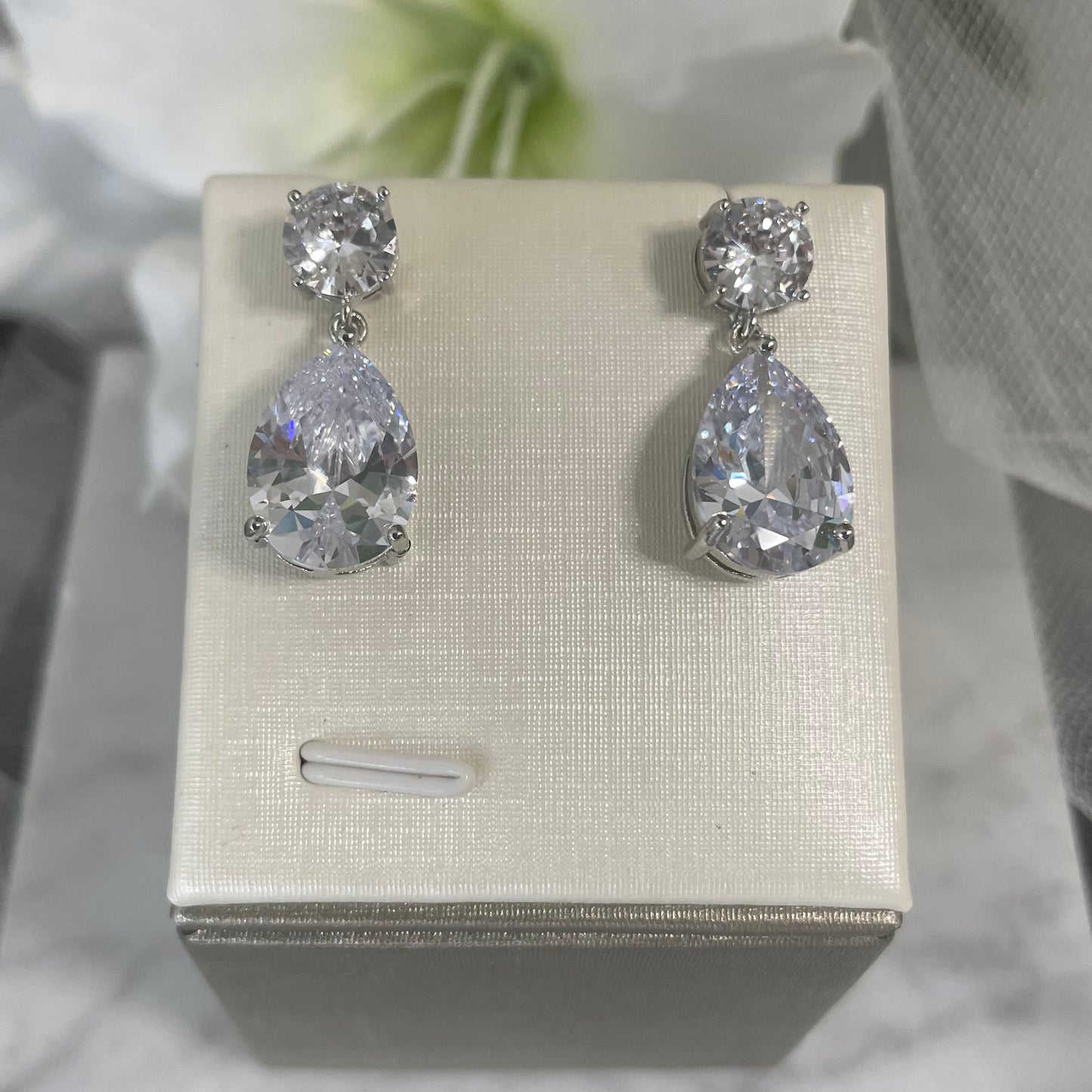 Sparkling Zoe Diamante Silver CZ Pear Shaped Drop Earrings featuring two distinct-sized cubic zirconia stones hanging from a small round CZ stone.