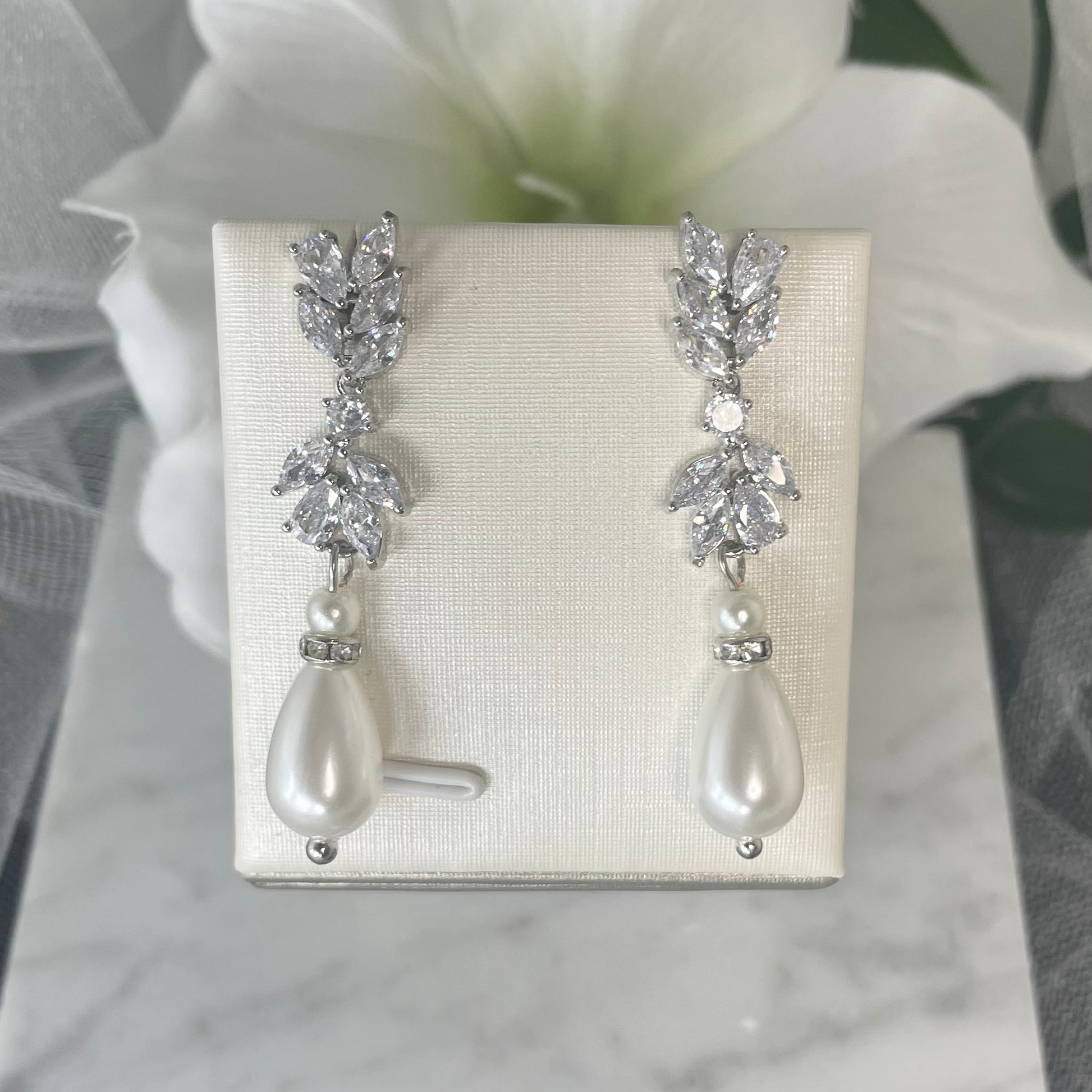 Nakira leaf-design pearl earrings with diamanté cubic zirconia detailing.