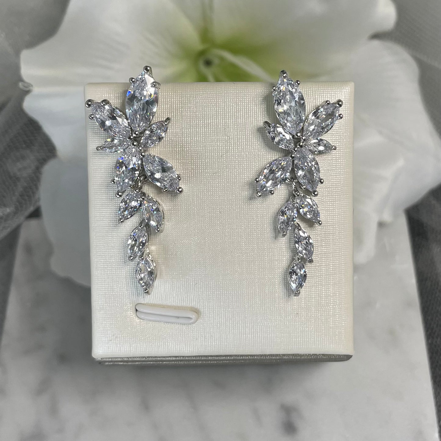 Lizzy cubic zirconia bridal earrings with cascading flower-shaped and leaf-like crystals, designed for sophisticated sparkle and elegance on your wedding day.