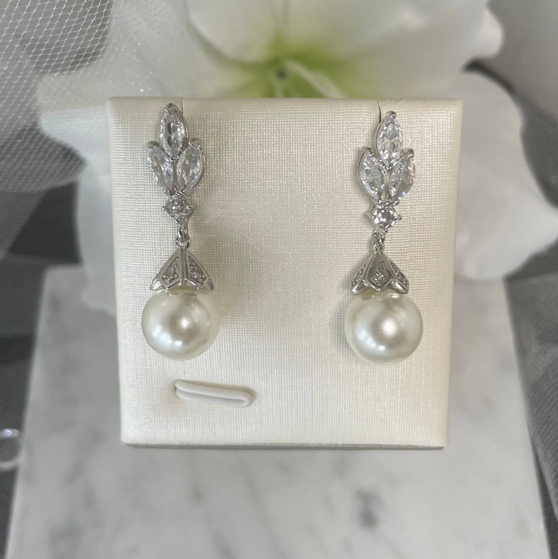 Elodie crystal pearl earrings with three leaf-like crystal design and a classic pearl drop in a secure claw setting, perfect for bridal elegance.