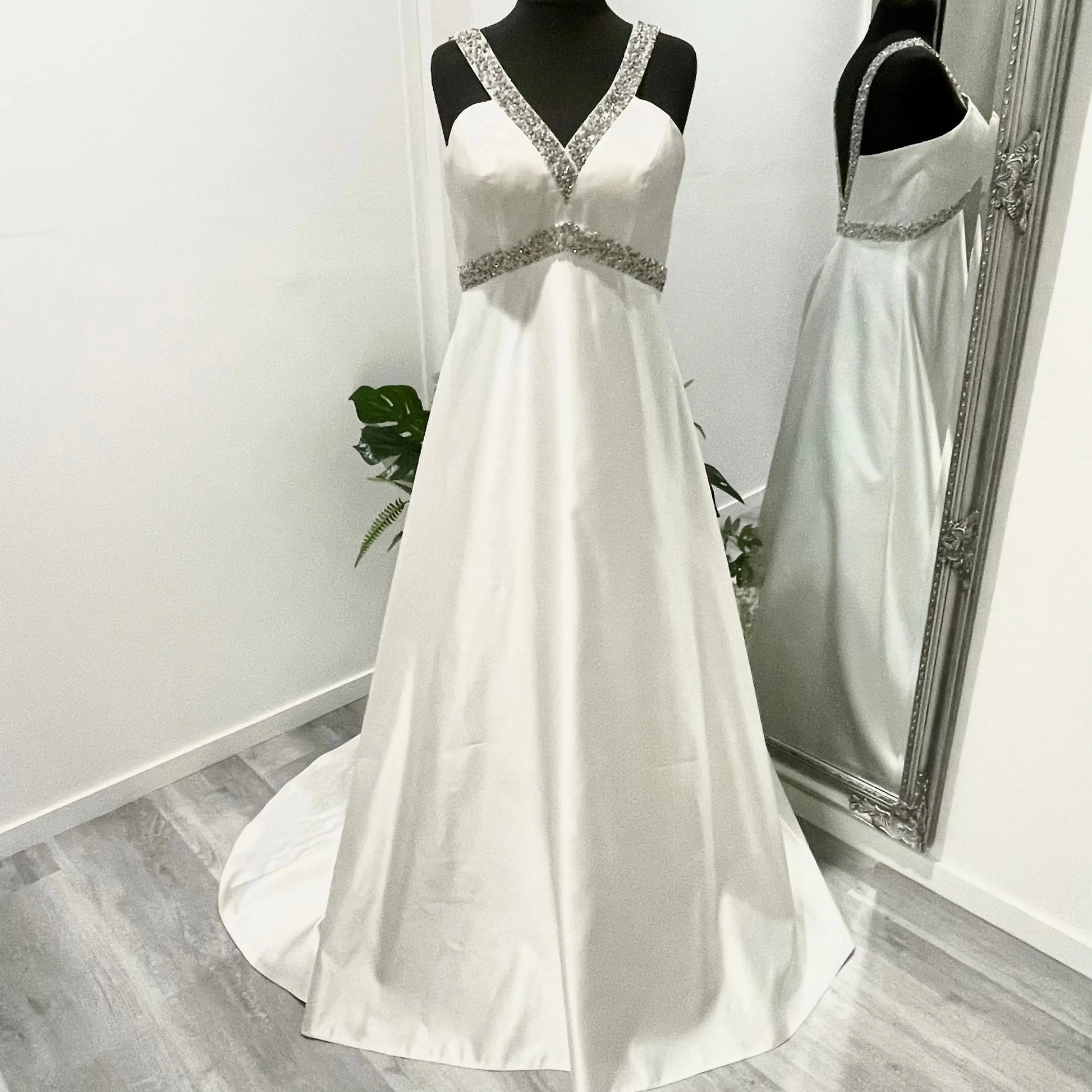 Bride in the Dynasty wedding gown, with V-neckline, intricate hand-beading, and a cascading train.