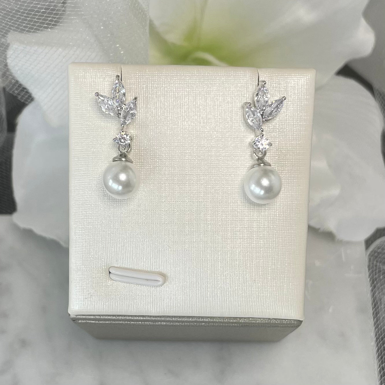 Selena leaf-design earrings with crystal embellishments and a dangling pearl accent.