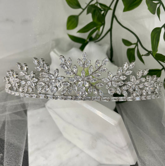 Darcy Bridal Tiara, featuring an exquisite floral and leaf design in silver, enhances bridal elegance with its intricate detailing and captivating sparkle.