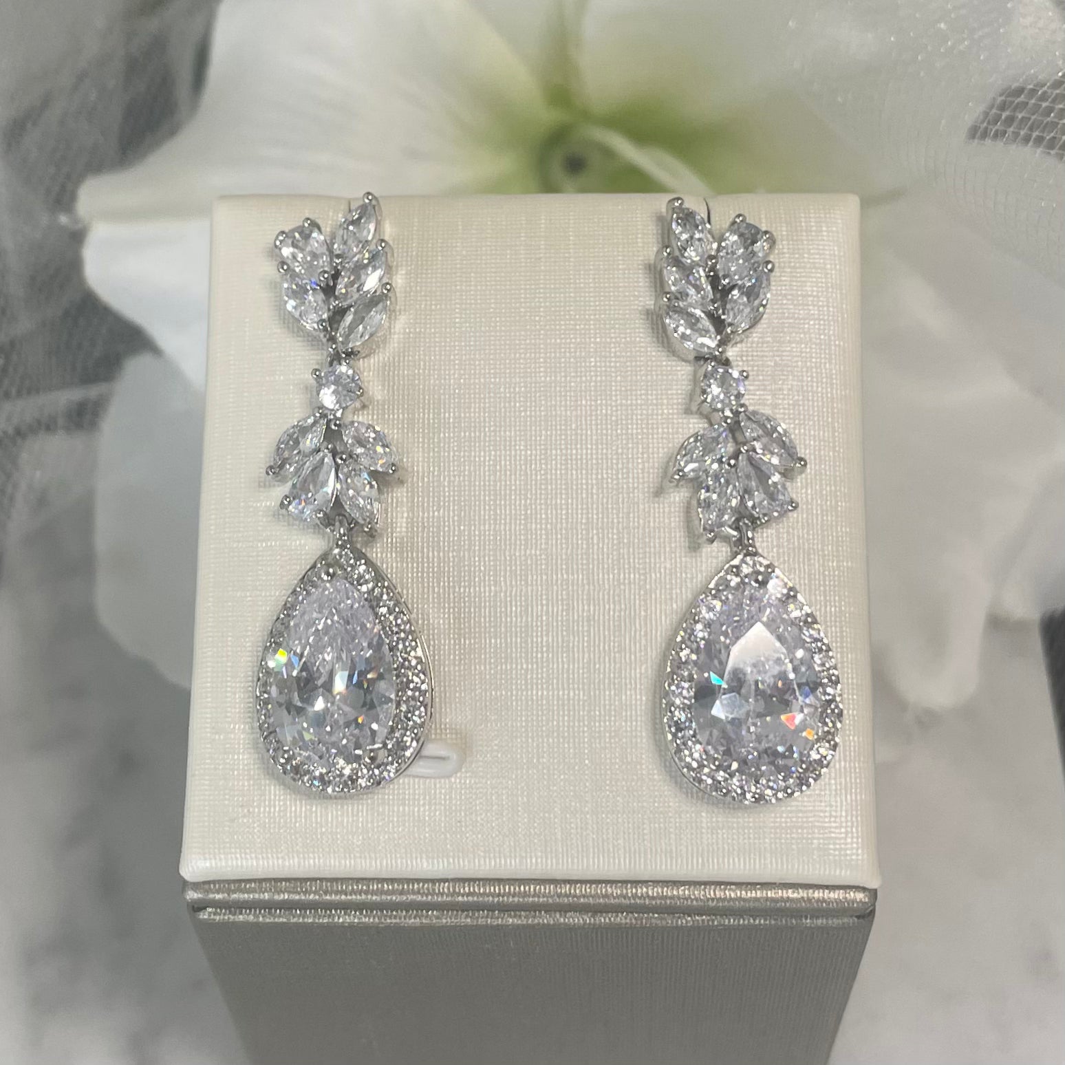 Bloom wedding earrings with leaf-shaped crystals and a central teardrop crystal surrounded by small rounds, crafted in elegant 18k gold/silver plated finish, perfect for bridal elegance.