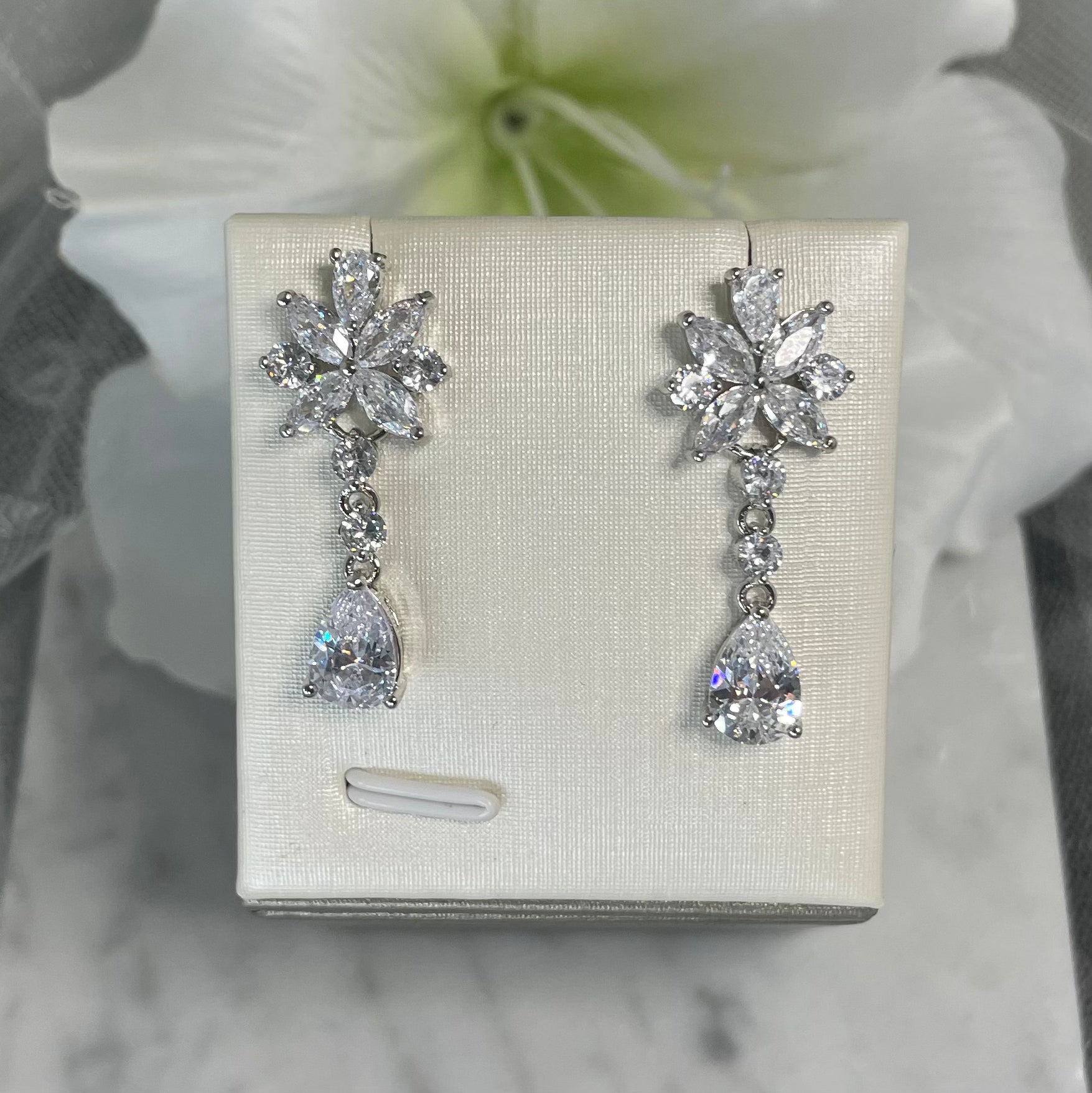 Christie cubic zirconia bridal earrings with a floral top, round crystals, and a teardrop finish, perfect for enhancing wedding day glamour.