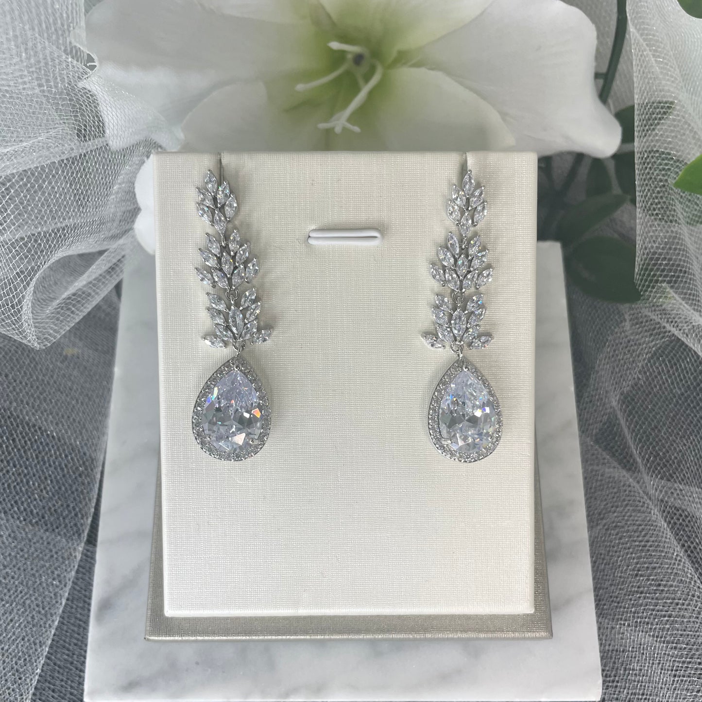 Madonna leaf-design crystal earrings with teardrop centrepiece and diamanté cubic zirconia accents.