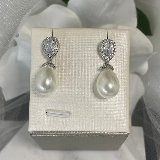 Kira crystal pearl wedding earrings featuring a dazzling central crystal with a halo of smaller crystals and a delicate teardrop pearl, crafted in elegant silver plating.