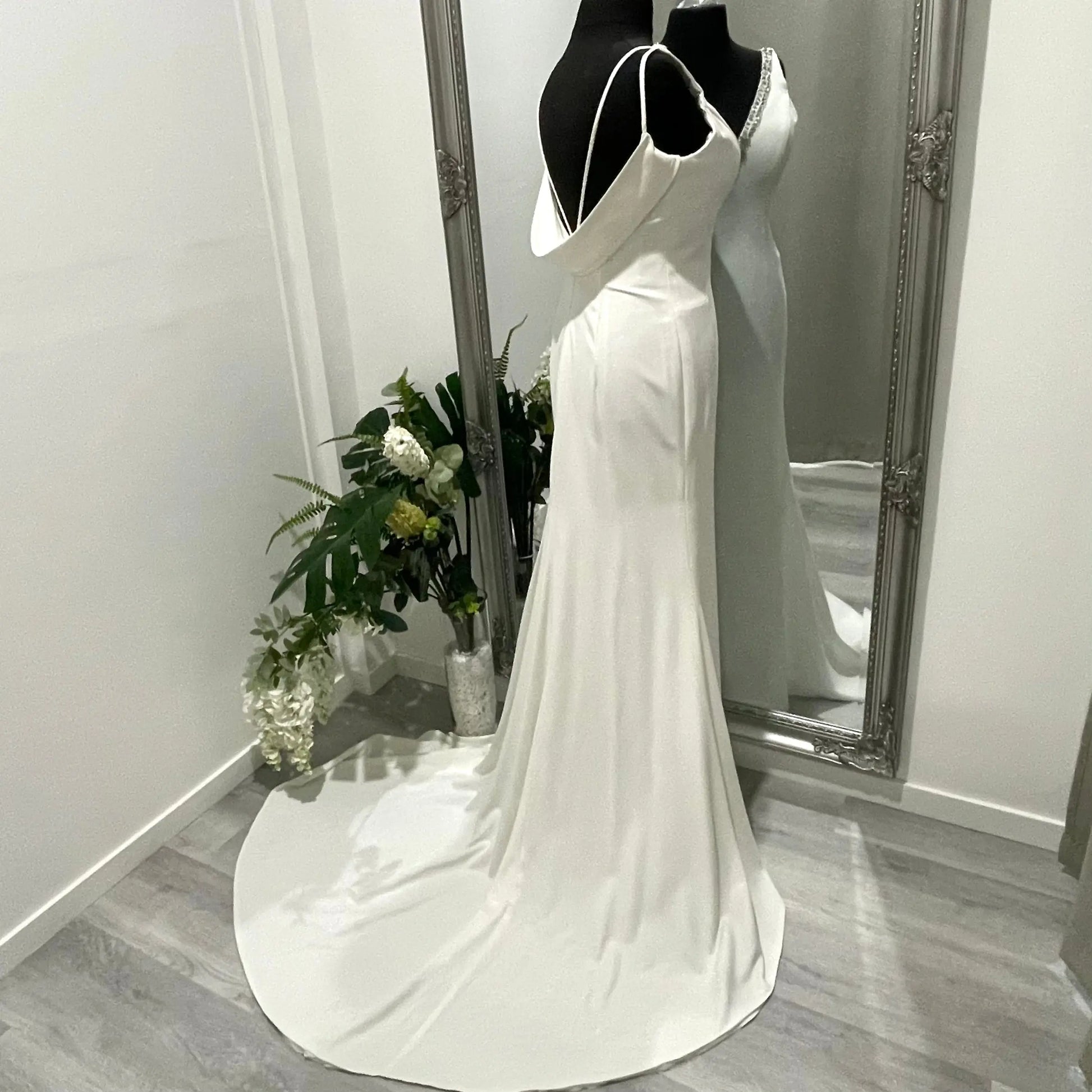 Bride in the Treasure wedding gown with beaded V-neckline, draped cow back, and cascading chapel train.