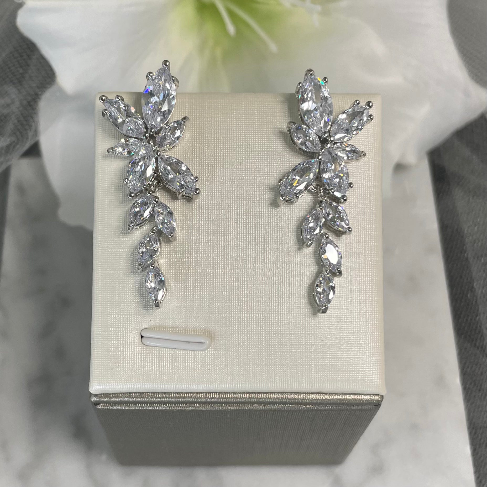 Lizzy cubic zirconia bridal earrings with cascading flower-shaped and leaf-like crystals, designed for sophisticated sparkle and elegance on your wedding day.