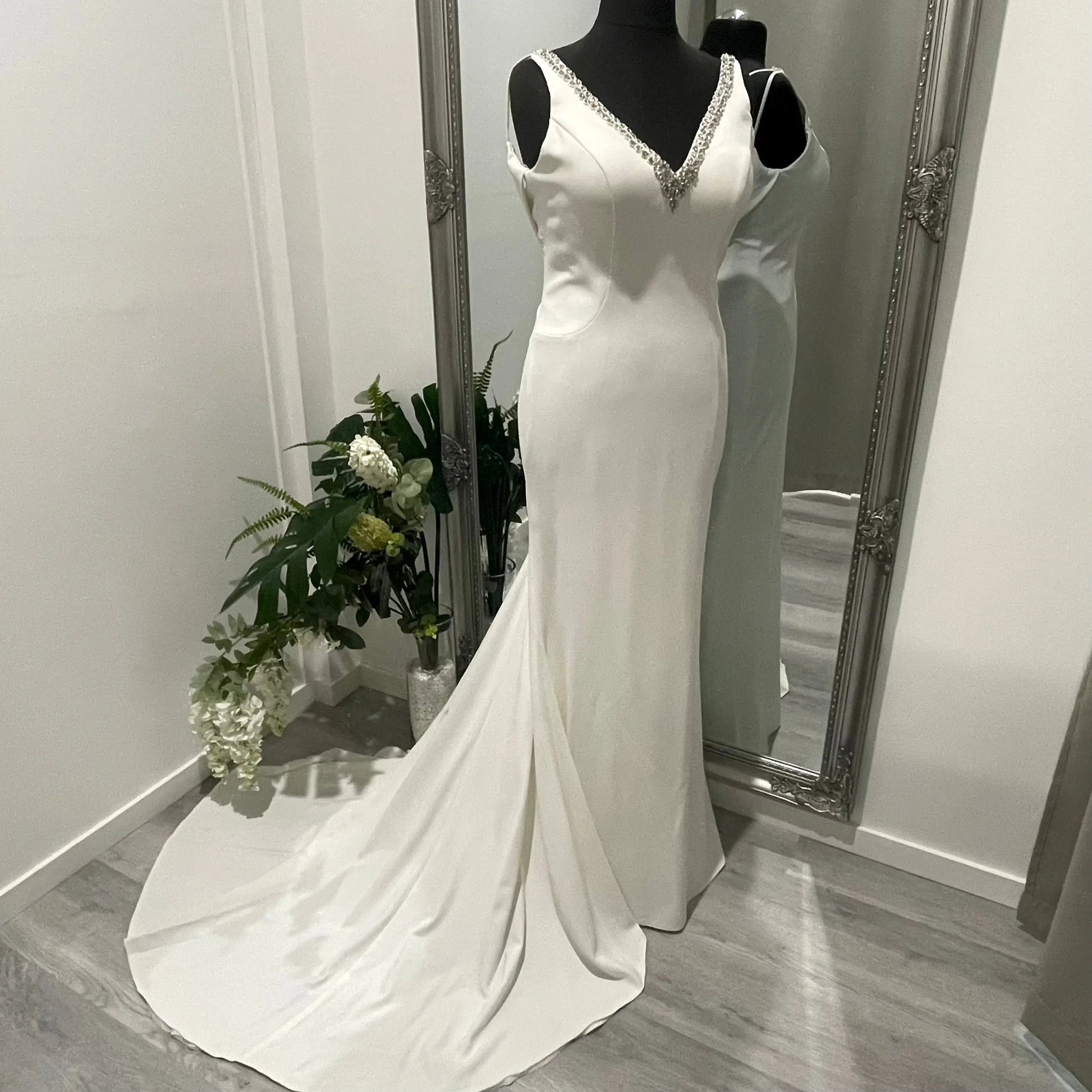 Bride in the Treasure wedding gown with beaded V-neckline, draped cow back, and cascading chapel train.