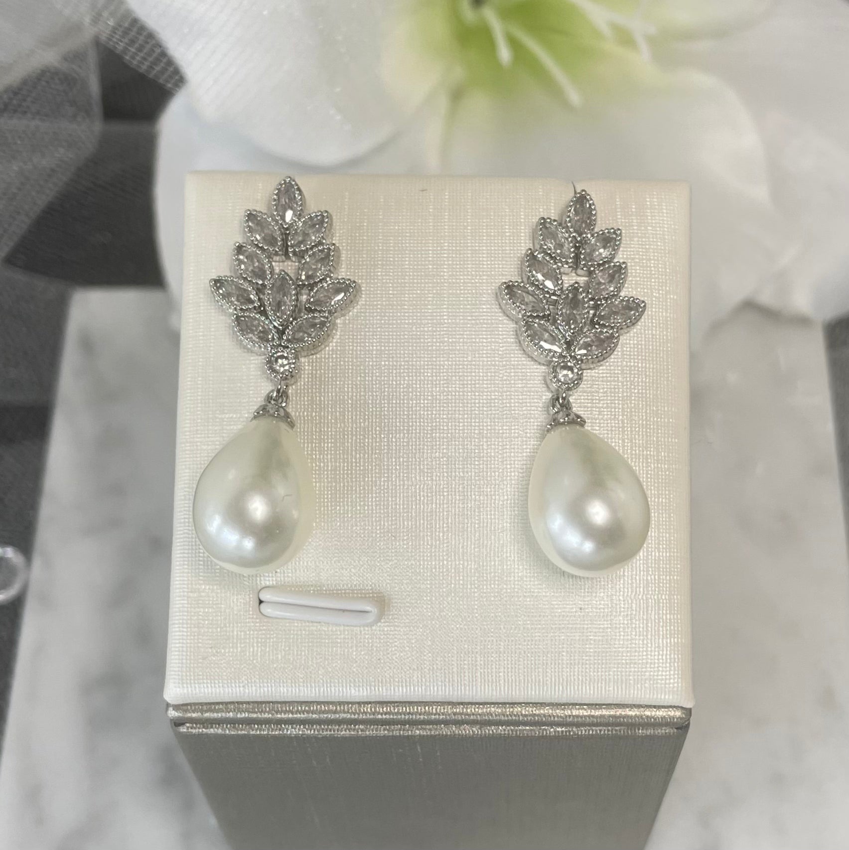 Elegant Mae Crystal Pearl Earrings with teardrop-shaped pearls and leaf-shaped crystal clusters, perfect for bridal and wedding wear.