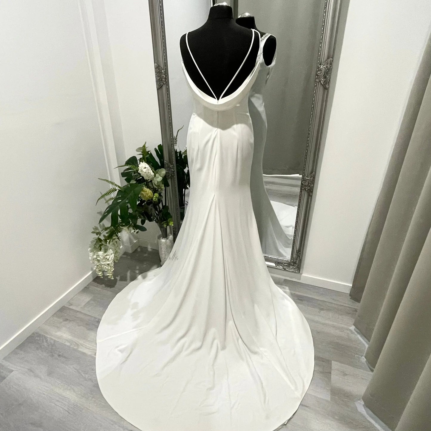 Bride in the Treasure wedding gown with beaded V-neckline, draped cow back, and cascading chapel train.