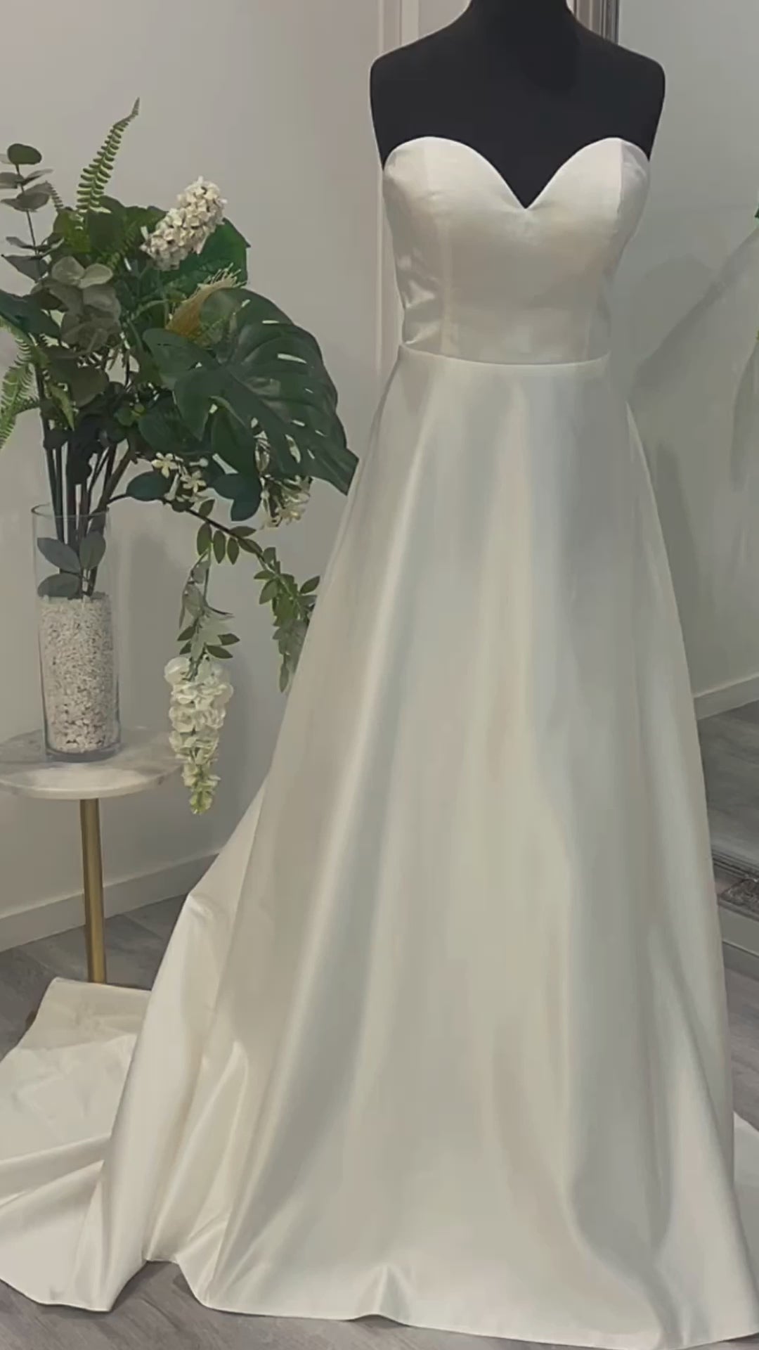 Sophisticated Daisy Wedding Gown with a deep V-neckline, displayed in Divine Bridal salon.