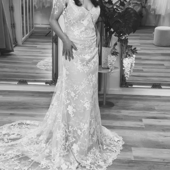 Bride in Koral wedding gown, showcasing the V-neckline, lace detailing, and the enchanting train.