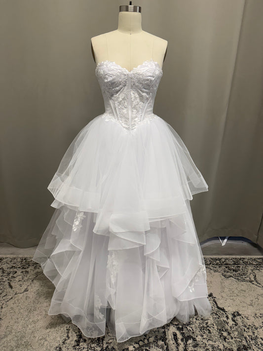 Skye V1 white floral lace debutante dress, front view on mannequin with strapless corset and full ruffle skirt