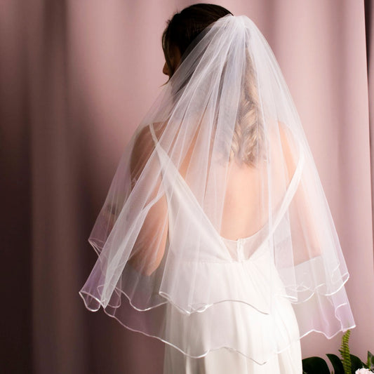 Ameli Wave Ribbon Veil in American tulle with a satin wave edge, combining elegance and style in white and ivory, perfect for a memorable bridal look.